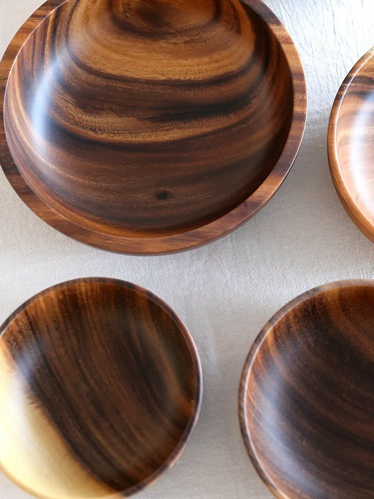 Handmade brown wooden bowl set showing multiple sizes from small to large on wooden table