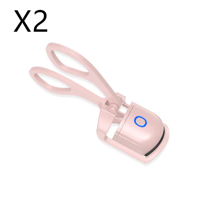White and pink USB rechargeable heated eyelash curler with curved silicone pad.