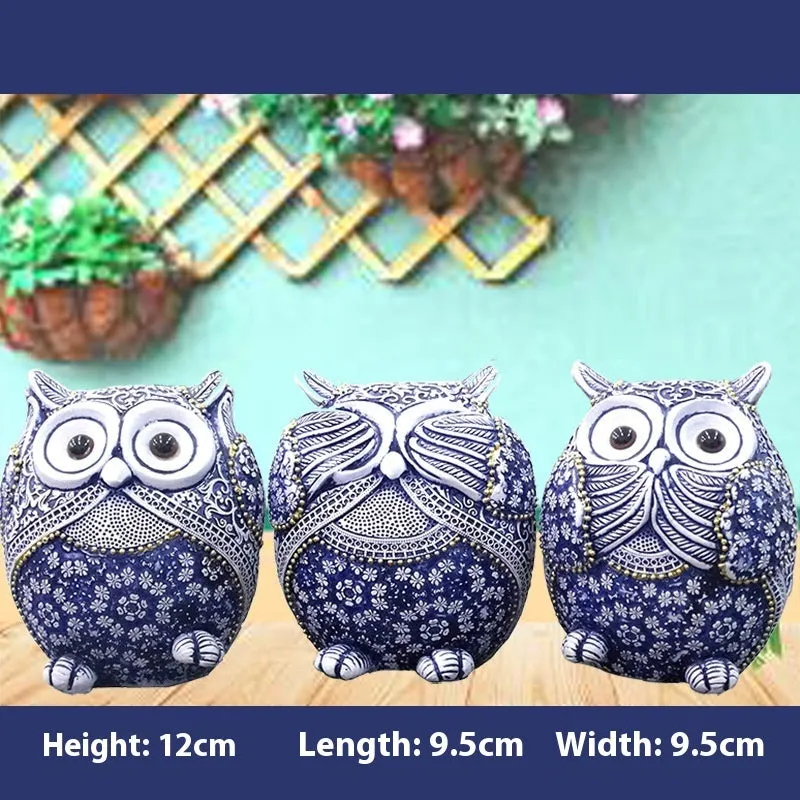 Three blue and white owl resin ornaments in large and small sizes on a white shelf