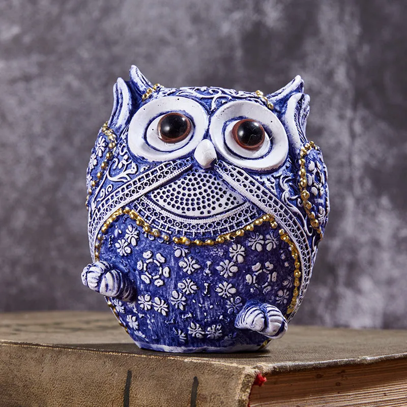 Three blue and white owl resin ornaments in large and small sizes on a white shelf