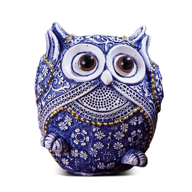 Three blue and white owl resin ornaments in large and small sizes on a white shelf