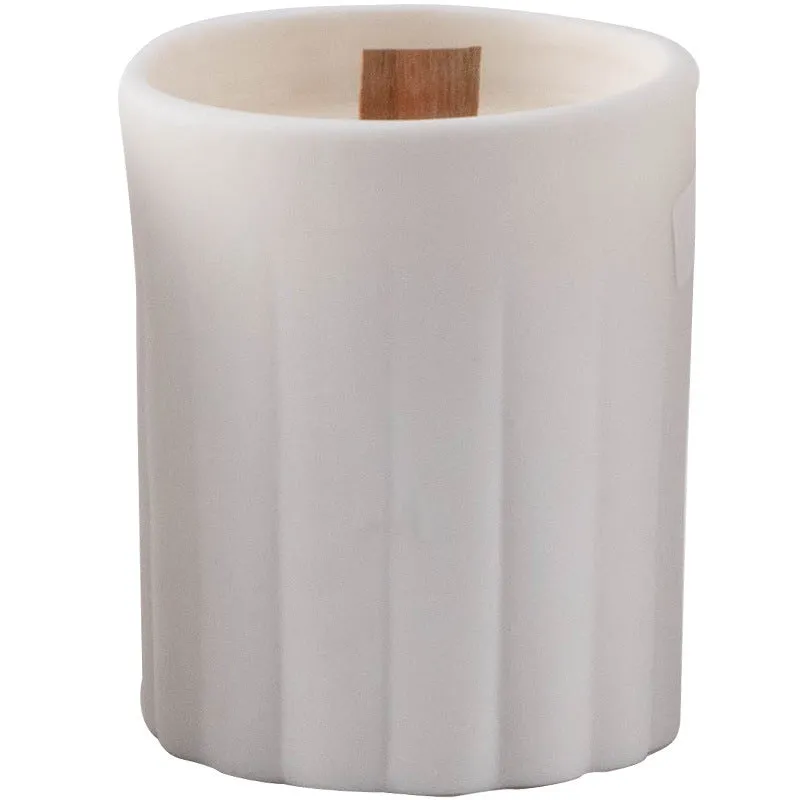 Ceramic candlestick with minimalist relief pattern on a dining table