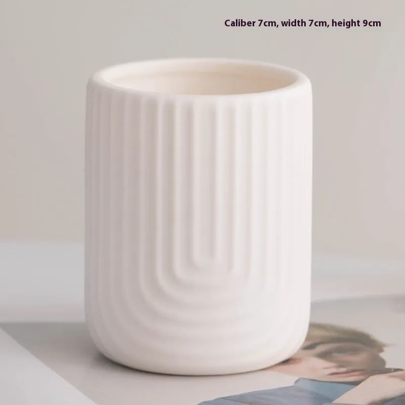 Ceramic candlestick with minimalist relief pattern on a dining table