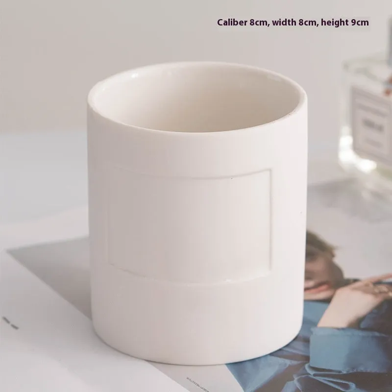 Ceramic candlestick with minimalist relief pattern on a dining table