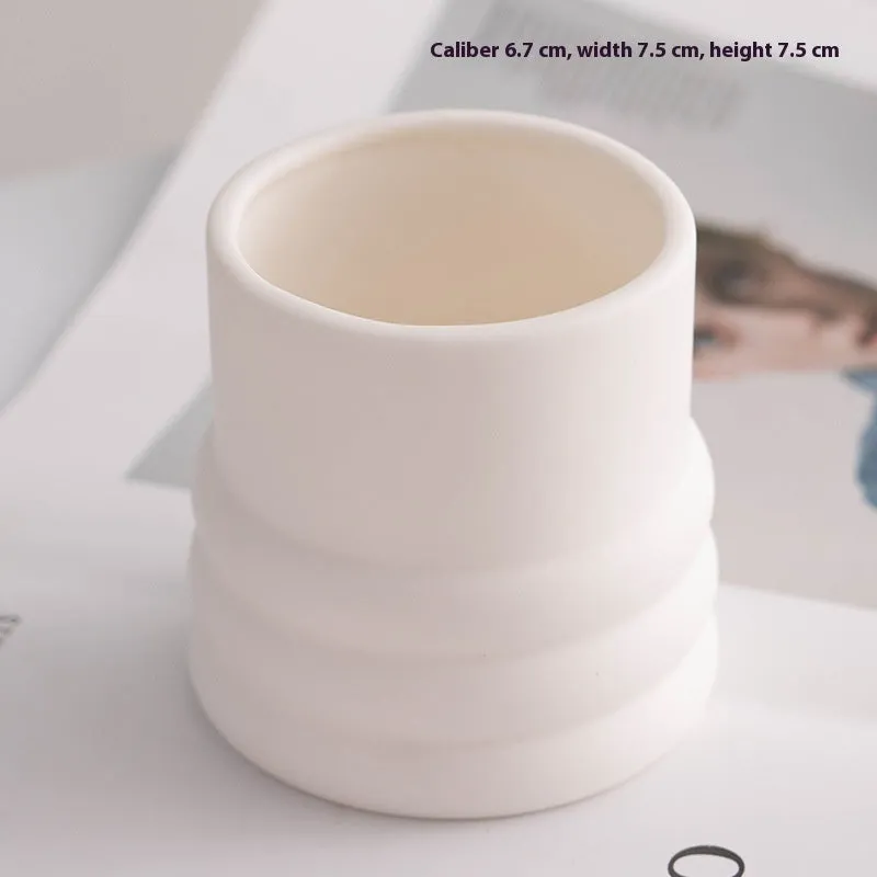 Ceramic candlestick with minimalist relief pattern on a dining table