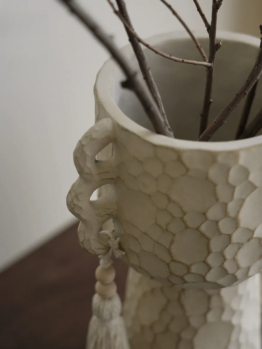 Ceramic binaural planter pot with decorative tassel flower motif on a white background.