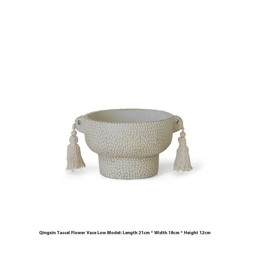 Ceramic binaural planter pot with decorative tassel flower motif on a white background.