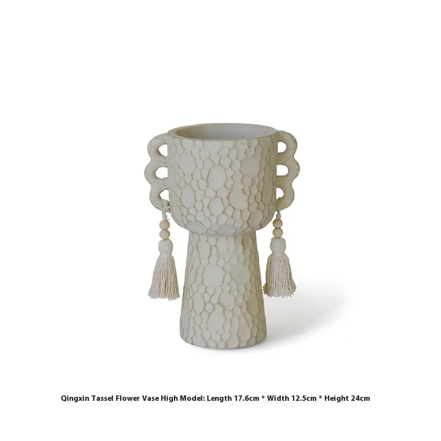 Ceramic binaural planter pot with decorative tassel flower motif on a white background.