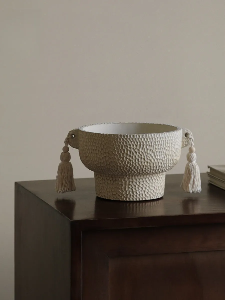 Ceramic binaural planter pot with decorative tassel flower motif on a white background.