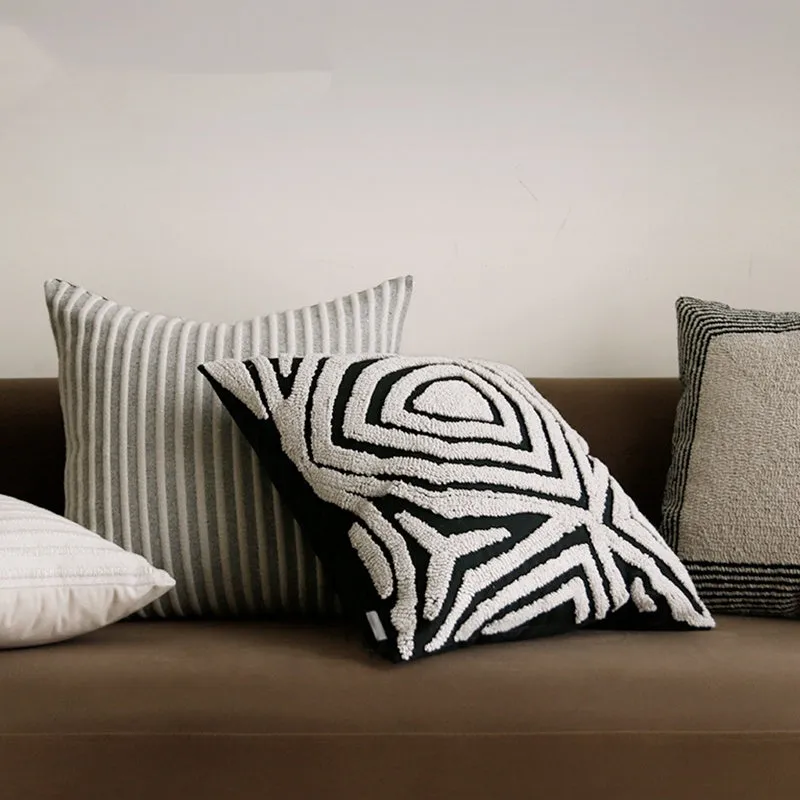 Black and white geometric patterned square and waist living room cushions with towel embroidery.