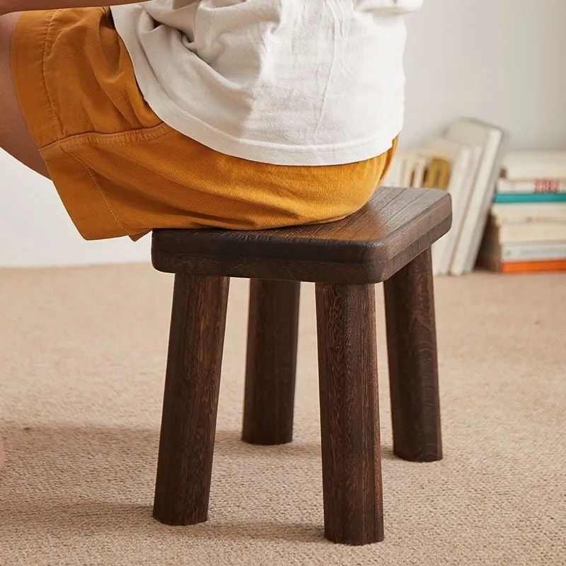 Solid wood household stool with distressed finish, shown as a changing stool or footrest.