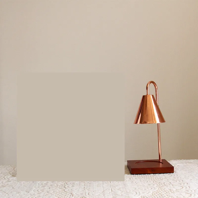 White and log coloured electric candle warmer lamp with dimmer switch on desk
