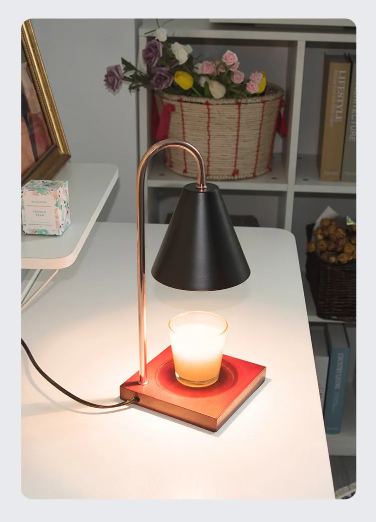 White and log coloured electric candle warmer lamp with dimmer switch on desk