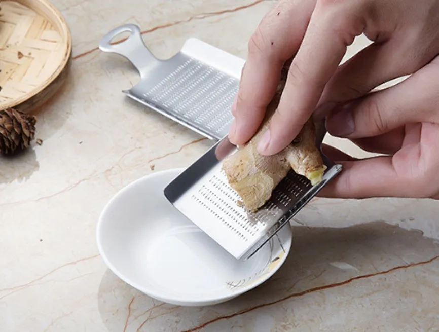Silver 304 stainless steel garlic press with ergonomic ABS handle on a kitchen counter