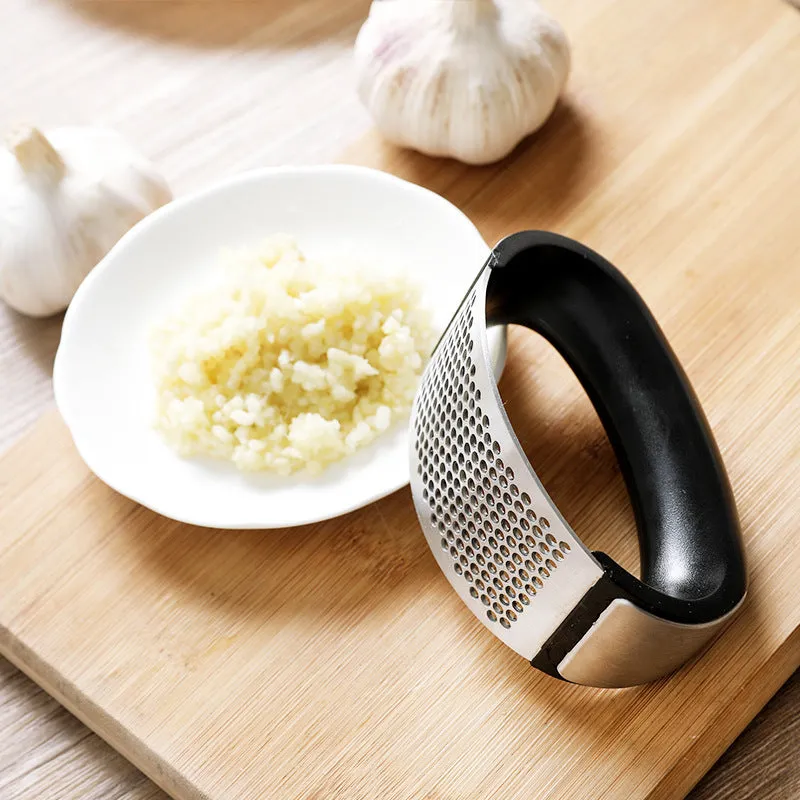 Silver 304 stainless steel garlic press with ergonomic ABS handle on a kitchen counter