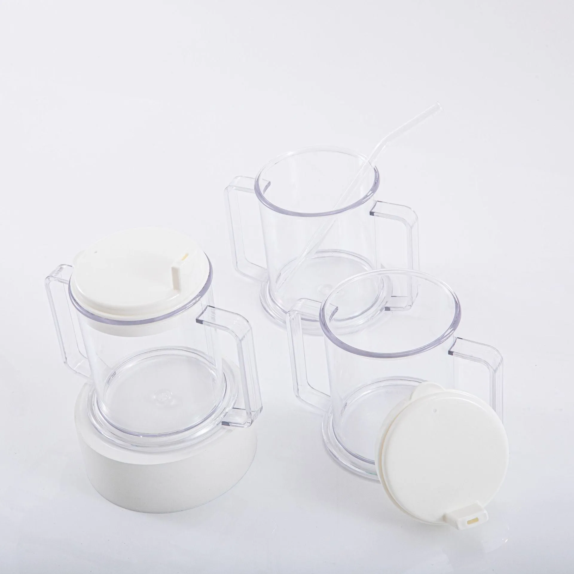 Transparent plastic drinking cup with a grey spill-proof lid on a white background.