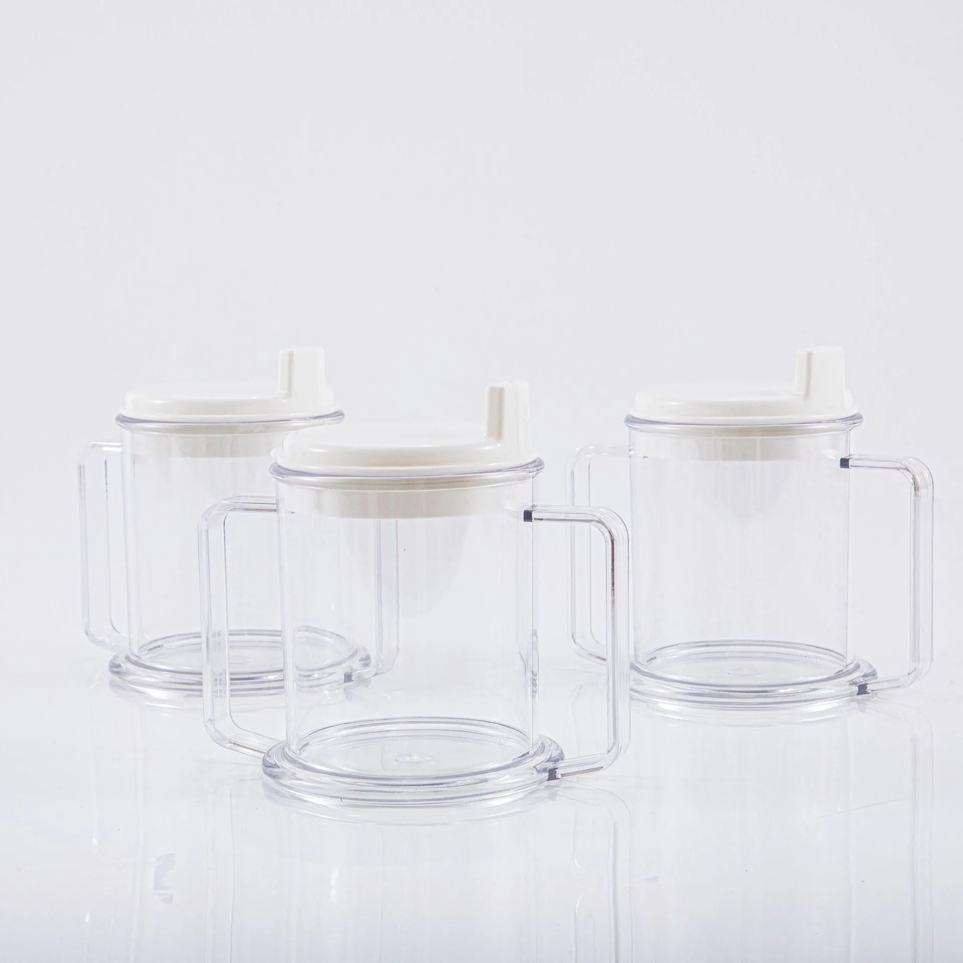 Transparent plastic drinking cup with a grey spill-proof lid on a white background.