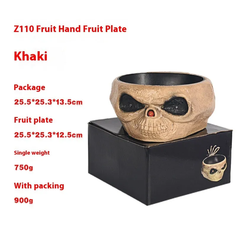 Plastic Halloween pumpkin candy bowl with motion activated skeleton hand, glowing red eyes, in Khaki colour, on a table with candy.