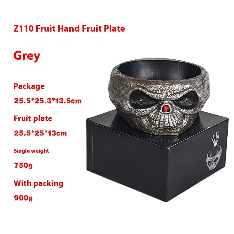 Plastic Halloween pumpkin candy bowl with motion activated skeleton hand, glowing red eyes, in Khaki colour, on a table with candy.