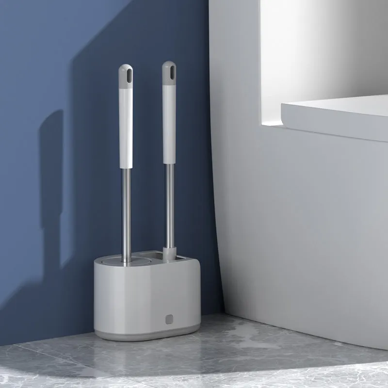 White silicone toilet brush set with long handle, soft TPR head, and second cleaning brush on a bathroom floor