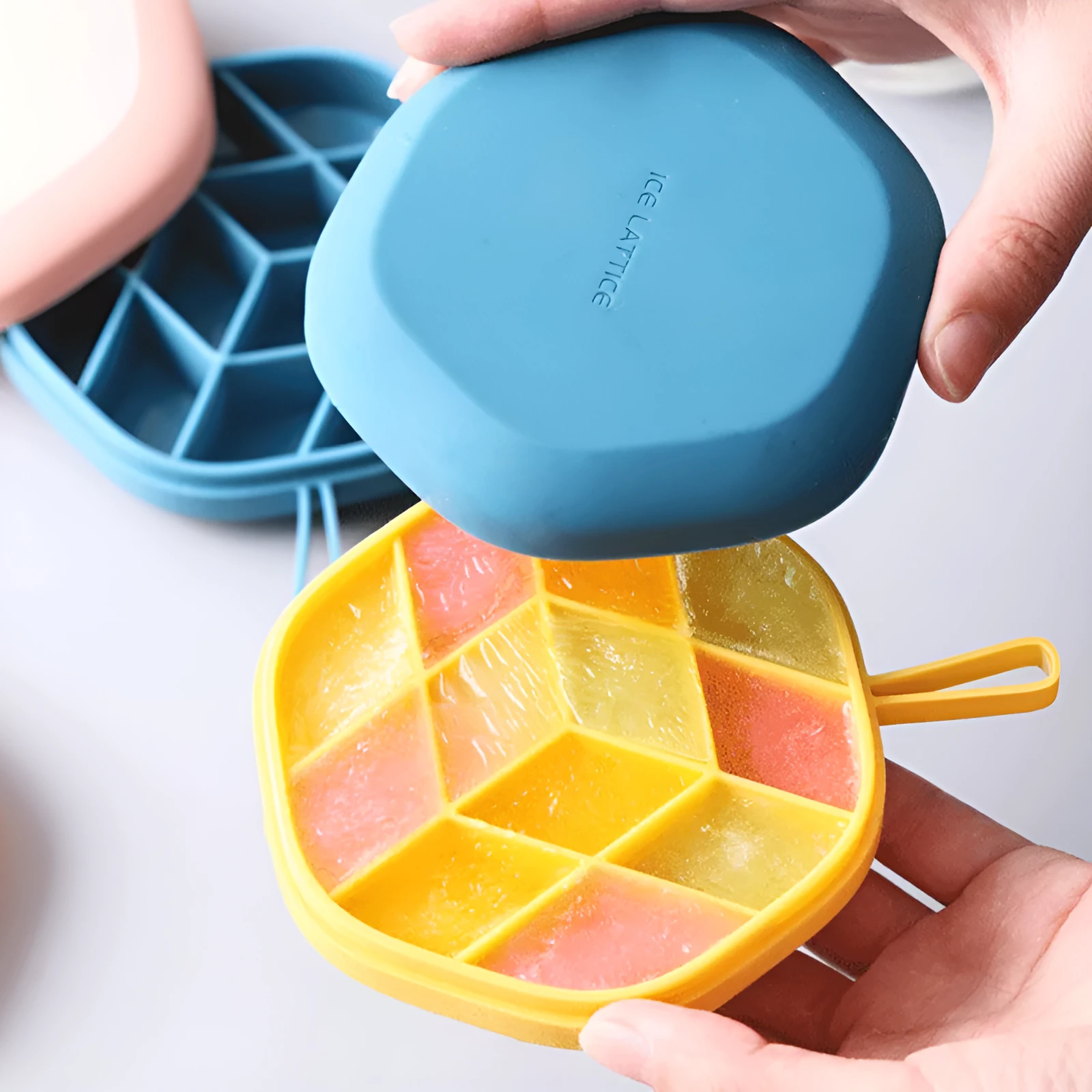 Silicone 12 cavity hexagon ice cube tray with silicone cover in blue, on a countertop