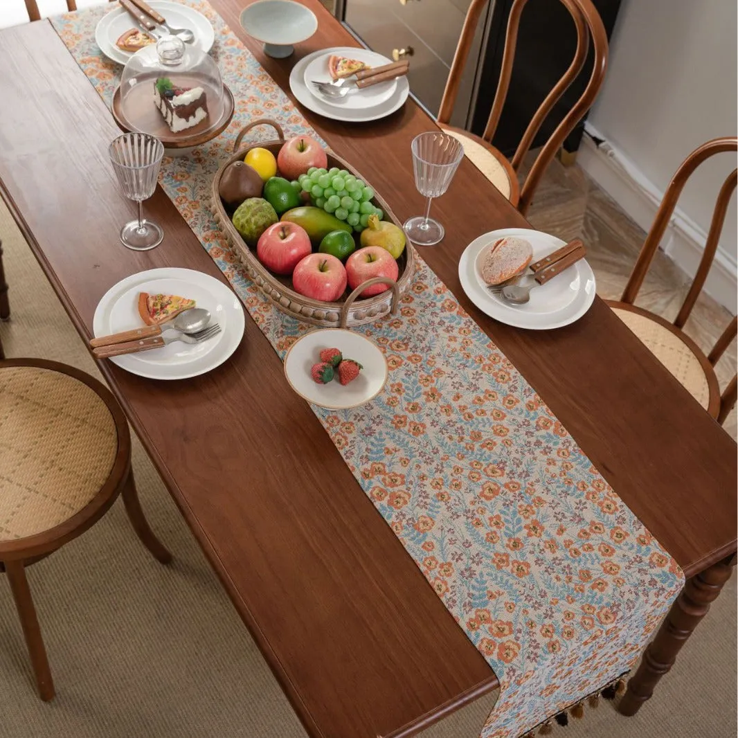 American-style beige jacquard table runner with long tassels and floral pattern on a dining table.