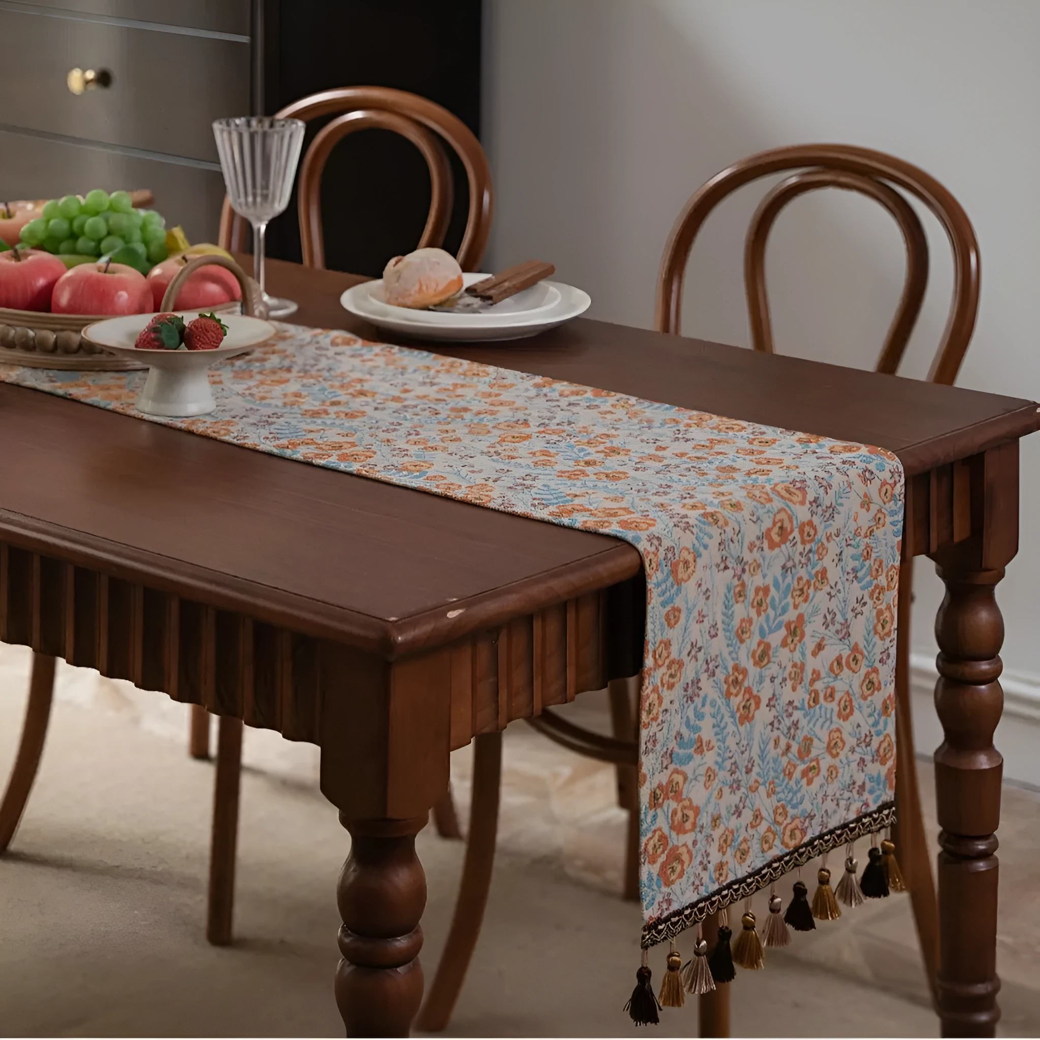 American-style beige jacquard table runner with long tassels and floral pattern on a dining table.