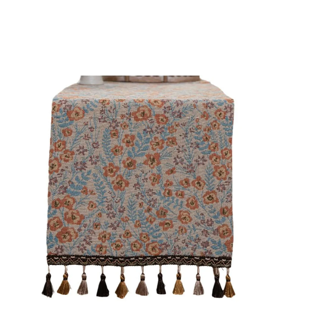 American-style beige jacquard table runner with long tassels and floral pattern on a dining table.