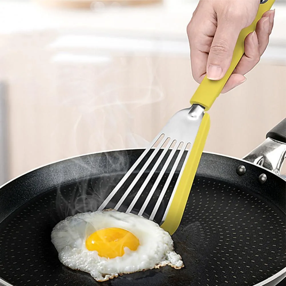 Green silicone fish spatula with 1mm thin slotter blade and hanging hole on a kitchen counter