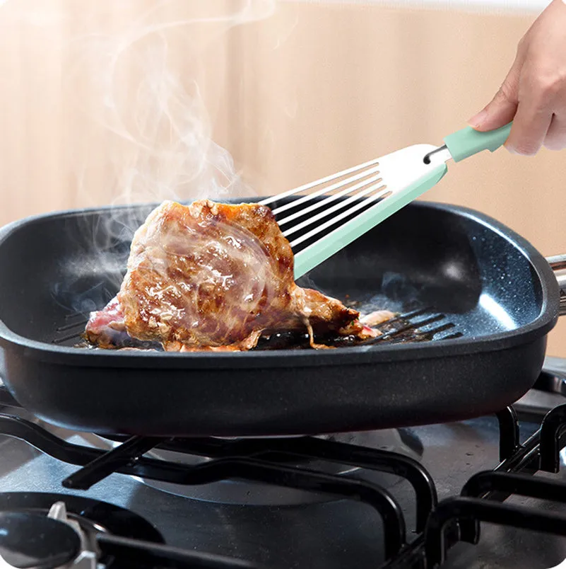 Green silicone fish spatula with 1mm thin slotter blade and hanging hole on a kitchen counter