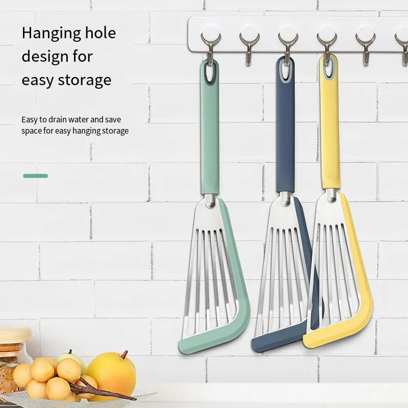 Green silicone fish spatula with 1mm thin slotter blade and hanging hole on a kitchen counter