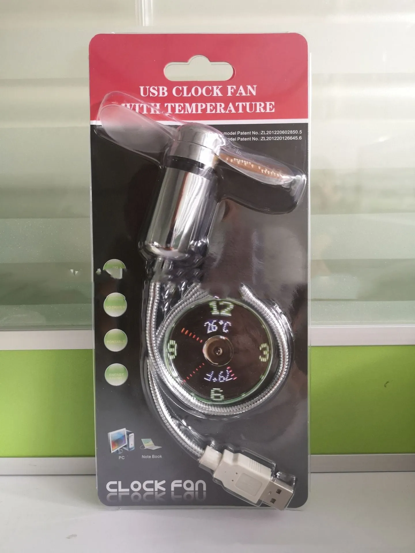 USB clock temperature fan with LED display, soft plastic blades, and flexible silver metal neck on a desk