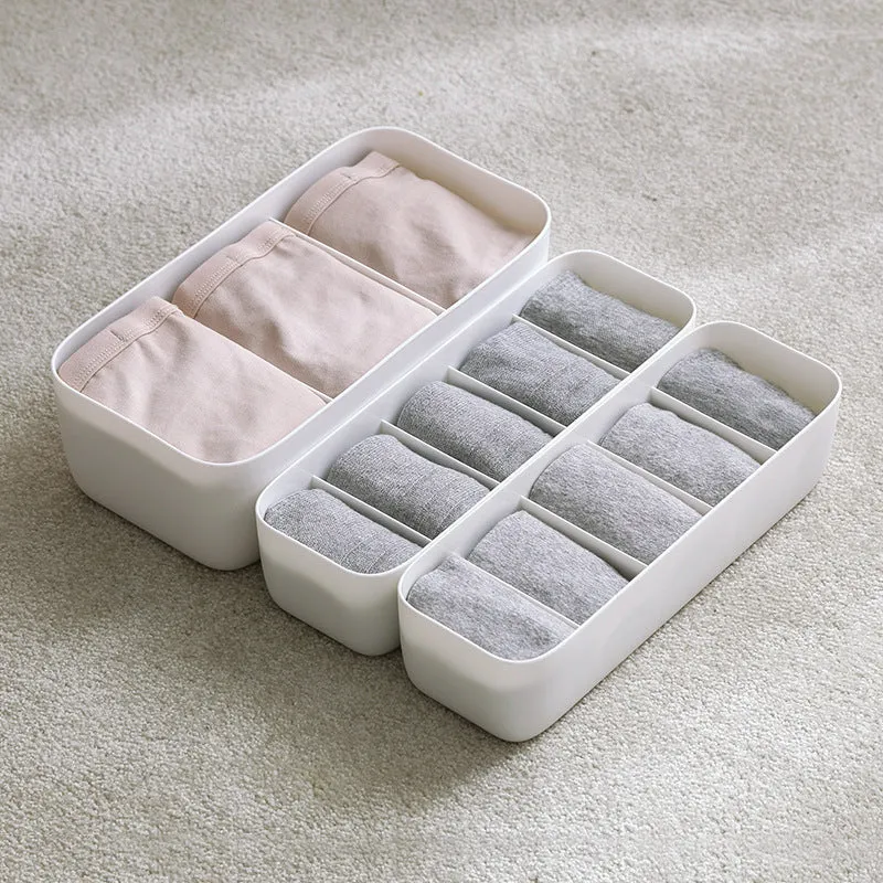 PP plastic socks and underwear storage box with grid compartments in apricot colour on a desktop