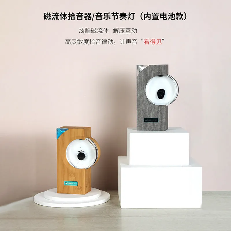 Dancing ferrofluid speaker in gray plastic casing with warm white light showing magnetic fluid shapes