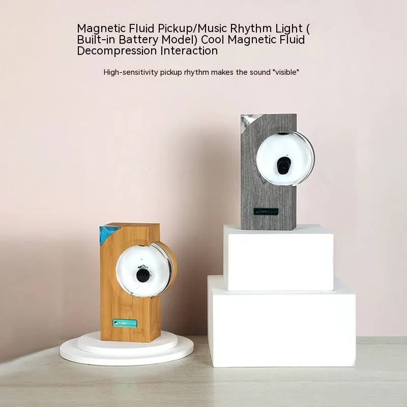 Dancing ferrofluid speaker in gray plastic casing with warm white light showing magnetic fluid shapes