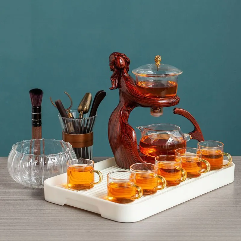 Maid semi-automatic glass tea set with heat-resistant borosilicate glass teapot, stainless steel filters, and Chinese style frame on a tea tray