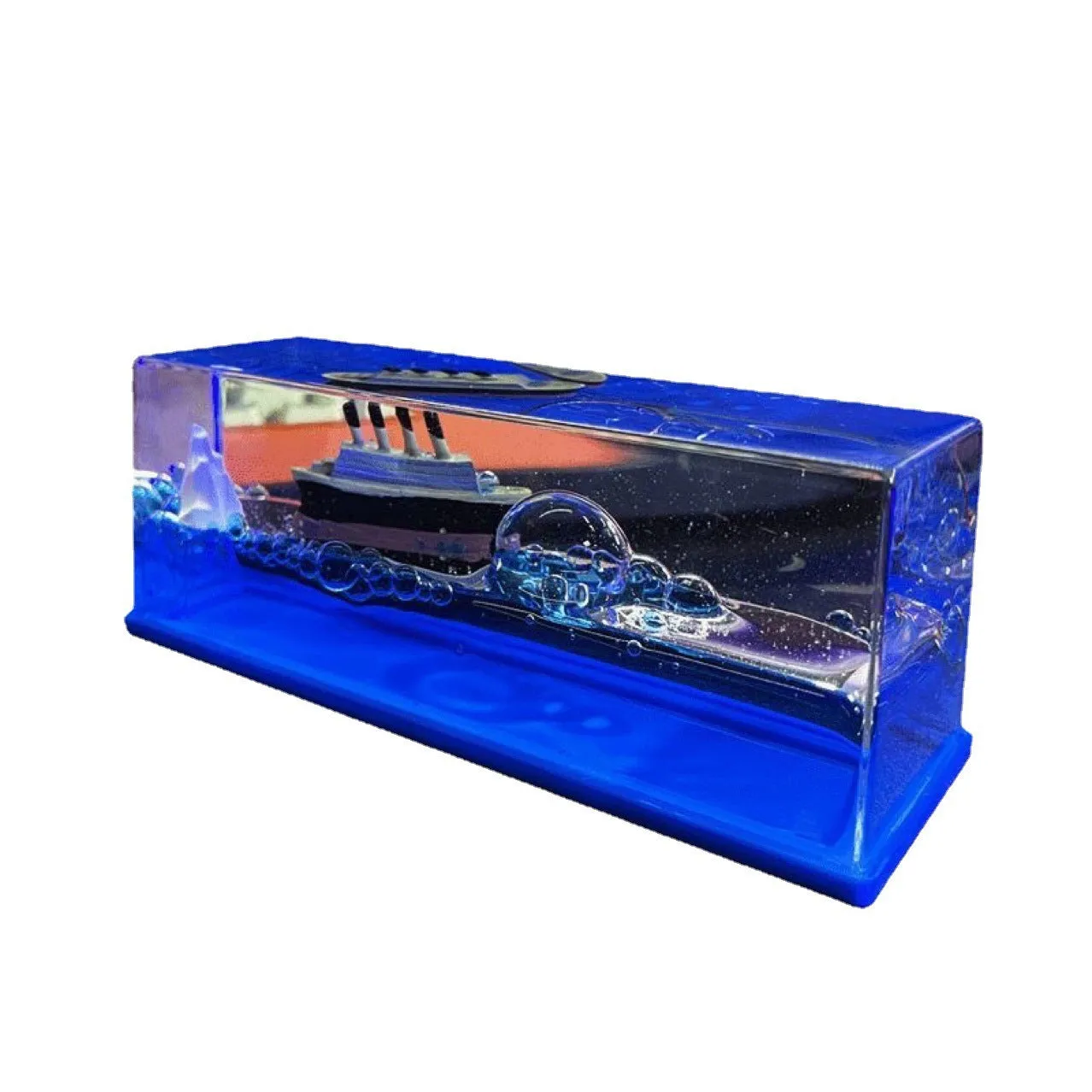 Fluid drift bottle with floating astronaut decoration in acrylic resin, black pearl pirate ship style, on a wooden desk.