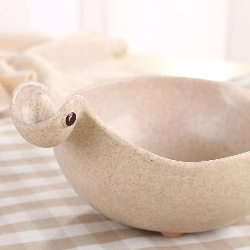 Cute tiny dinosaur bowl made of natural wheat straw fibre in pink, green, and beige colours, lightweight non-slip unbreakable design