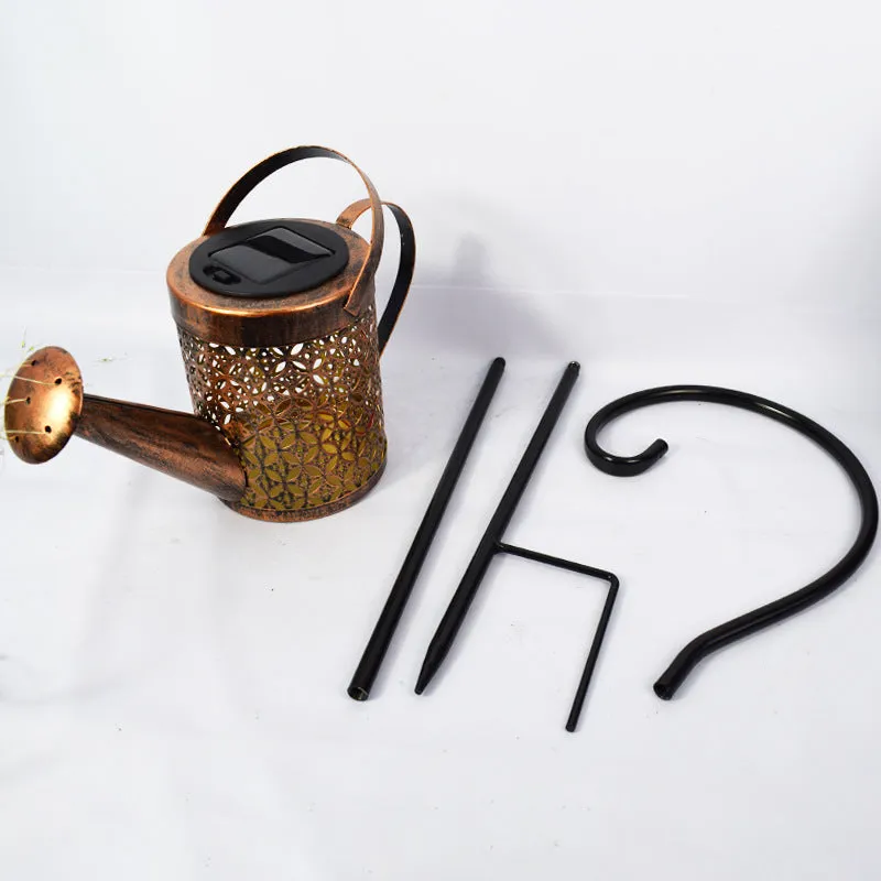 Solar watering can garden lamp with hollow-out iron shower body and 36 warm white LED lights on copper wire, installed in grass