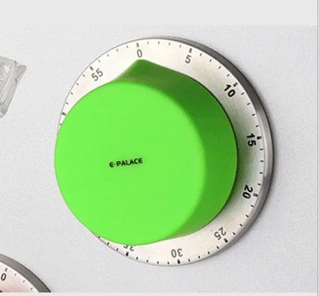 Green kitchen stainless steel mechanical timer with 60-minute dial on metal surface