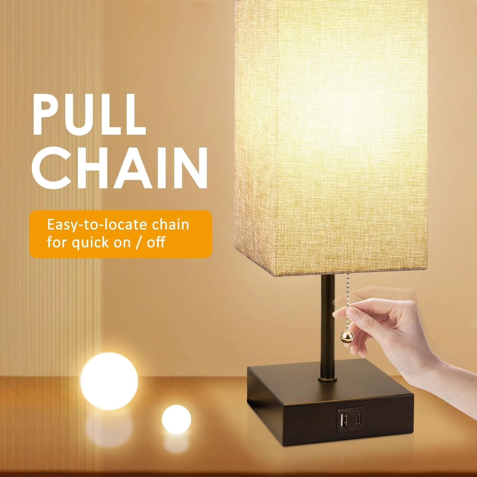 Small bedside table lamp with fabric shade and USB charging ports on a nightstand with pull chain control