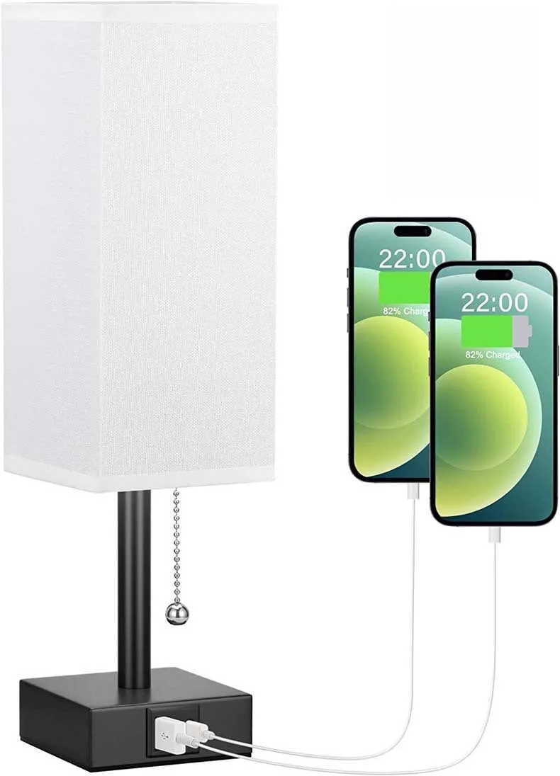 Small bedside table lamp with fabric shade and USB charging ports on a nightstand with pull chain control