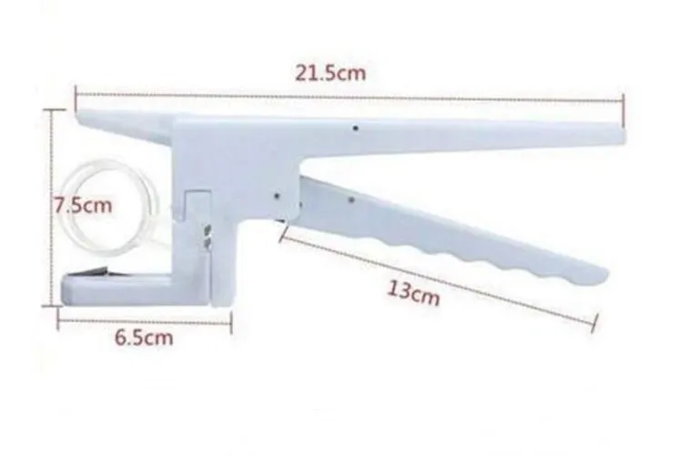 White handheld egg shell cracker with curved silicone grip and metal mechanism on a kitchen counter