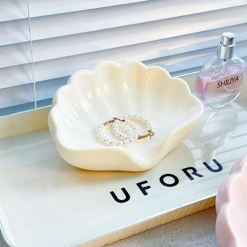 White shell-shaped plastic soap dish for bathroom countertop.