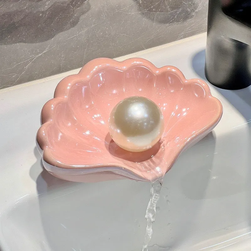 White shell-shaped plastic soap dish for bathroom countertop.