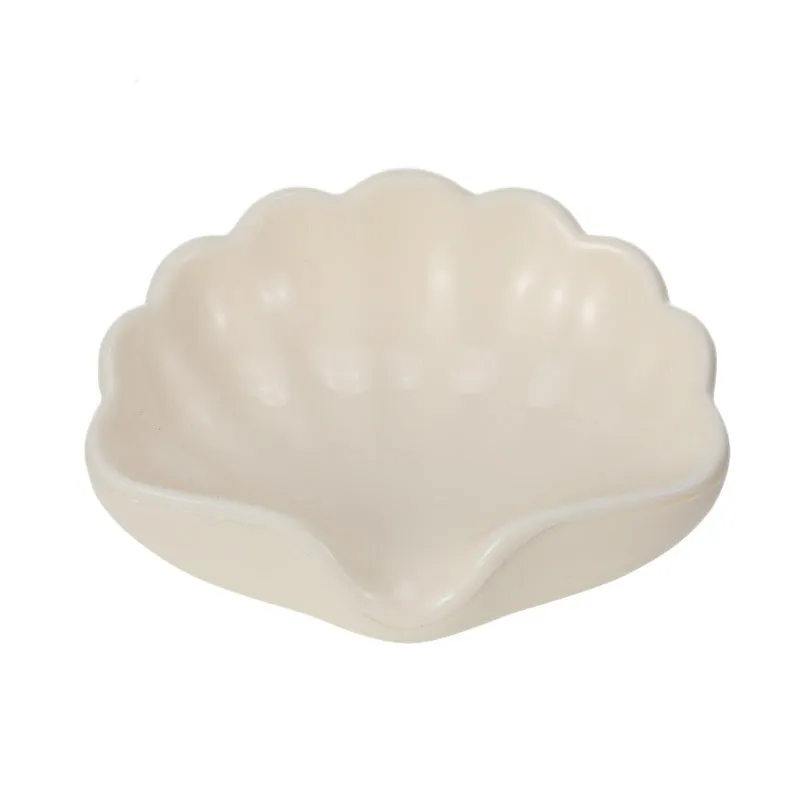 White shell-shaped plastic soap dish for bathroom countertop.