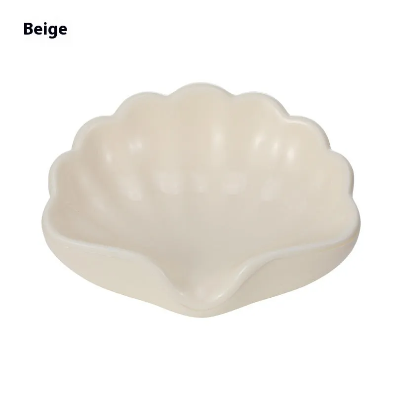 White shell-shaped plastic soap dish for bathroom countertop.
