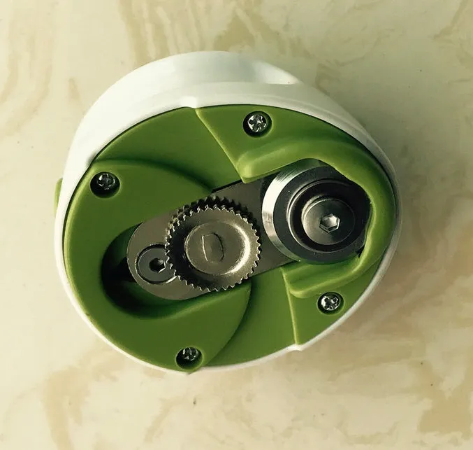 Compact manual can opener with stainless steel blade and ABS plastic body on a kitchen counter