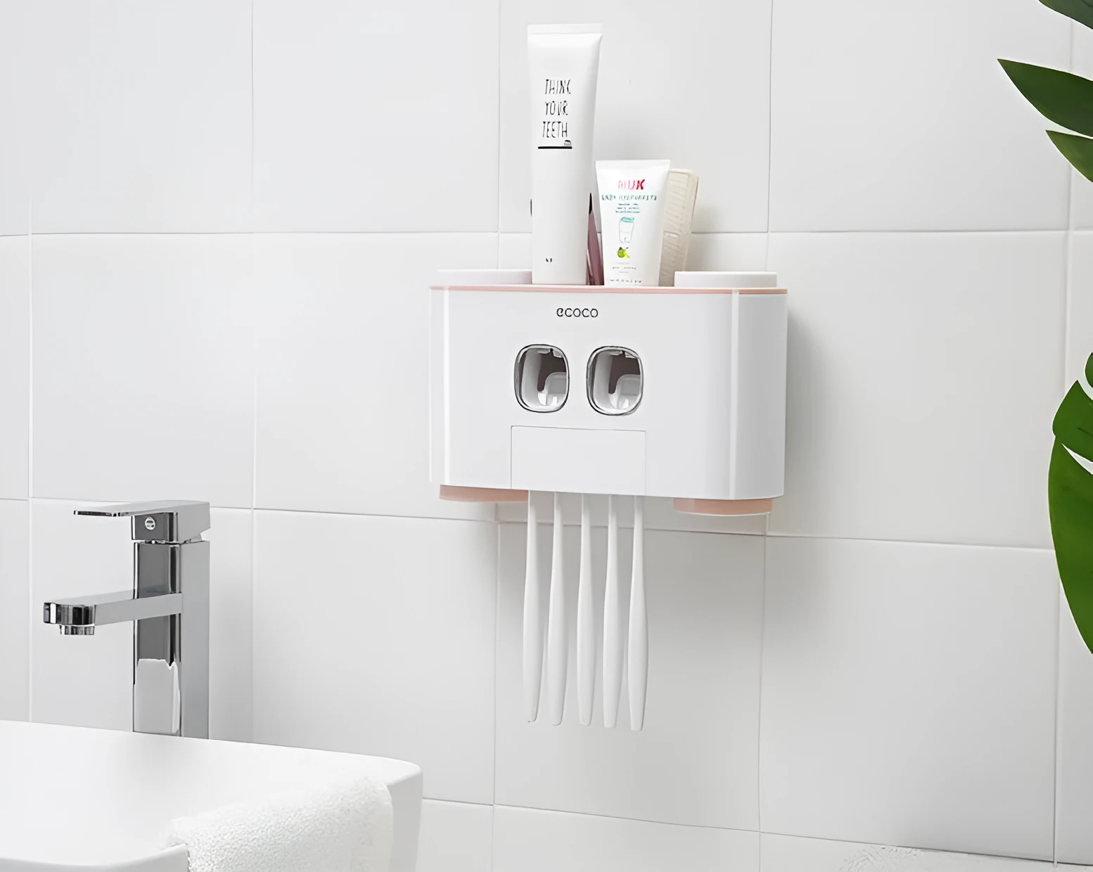 Plastic wall-mounted toothbrush holder with four magnetic cups in pink, blue, and green for family bathroom