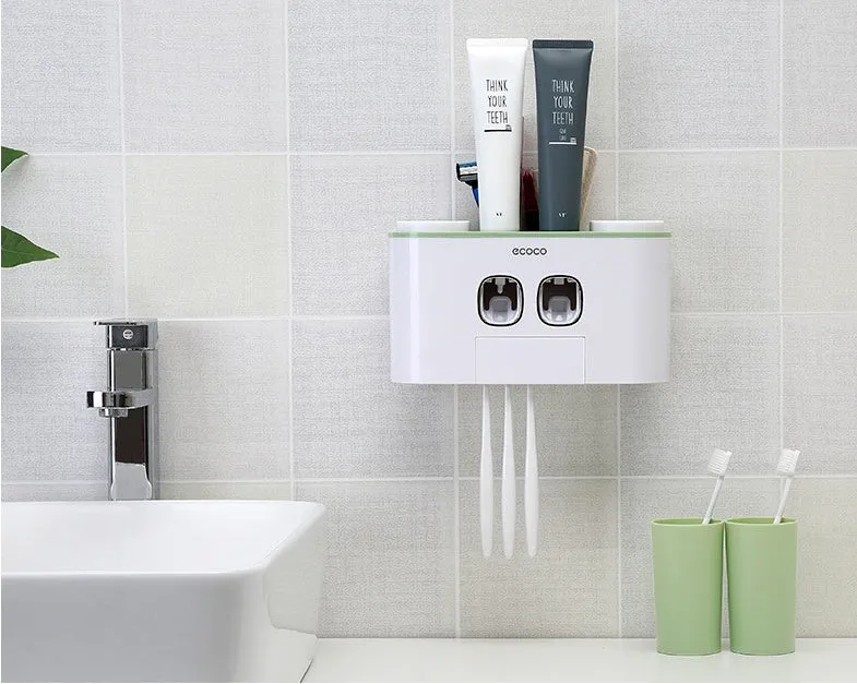 Plastic wall-mounted toothbrush holder with four magnetic cups in pink, blue, and green for family bathroom